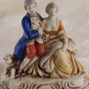 Ceramic couple sitting with a lamb